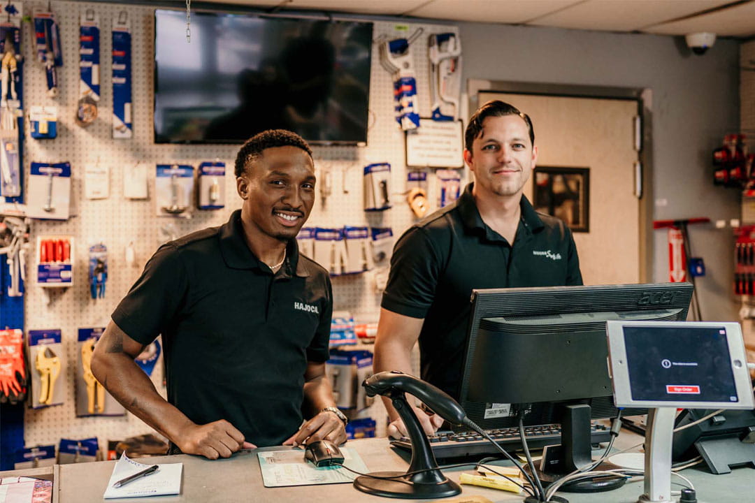 Hajoca Sales & Leadership candidates reviewing information on a computer at a plumbing service counter